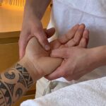 Nadja Stenzl beim Ausüben einer koreanischen Handmassage an der Handfläche eines Kunden.